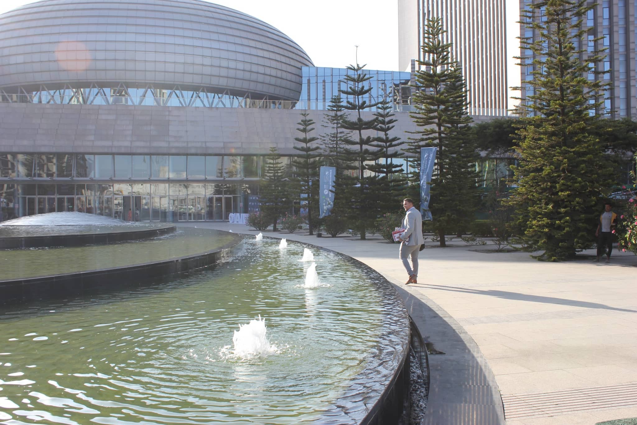 Der Vorplatz des Hauptquartiers der Afrikanischen Union in Addis Abeba: ein Wasserbecken mit Fontänen, dahinter die Kuppel der Konferenzhalle und der Büroturm.